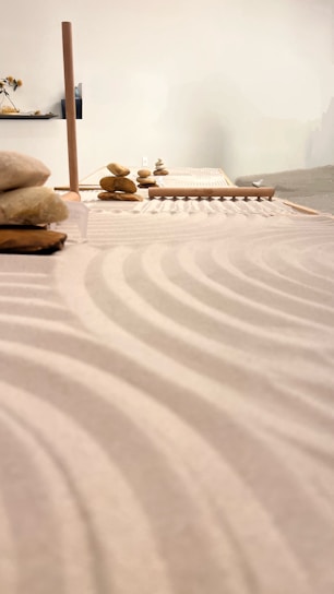 A serene zen garden with smooth stones and raked sand under soft morning light.