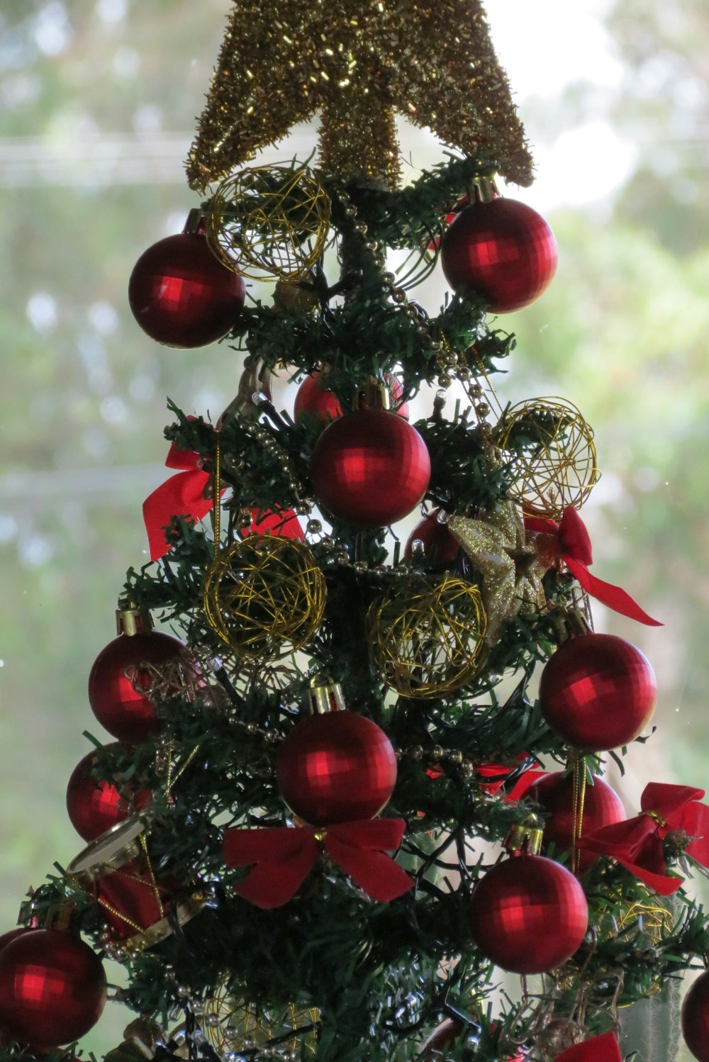 a christmas tree with red ornaments and a star on top