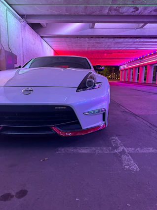 Sleek custom GTA 5 car with glowing pink underlights in a dark urban setting