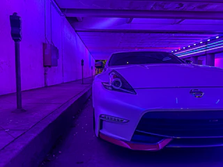 Phone frame showcasing a sleek car parking game with neon city lights background.