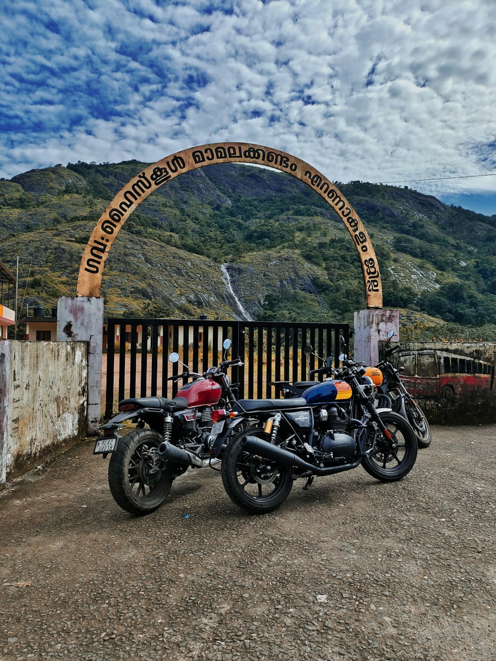 two motorcycles are parked in front of a gate