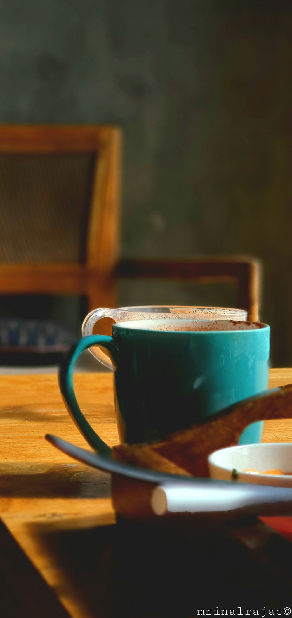 a cup of coffee sitting on top of a wooden table