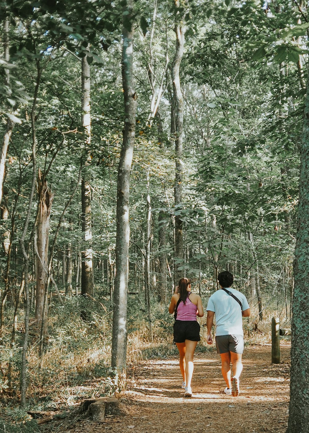 a man and a woman walking through a forest