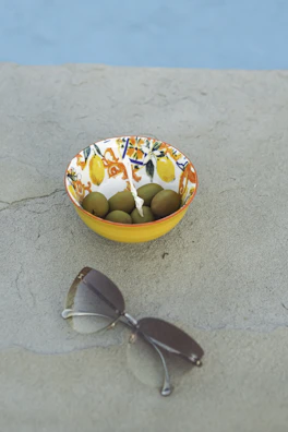 Colorful assortment of Provençal olives in ceramic bowls with herbs sprinkled around.