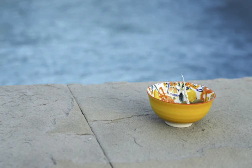 A close-up of a beautifully crafted Moroccan ceramic bowl with vibrant patterns glowing softly under neon blue light.