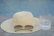 A stylish yellow and white bucket hat placed on a sunny outdoor table.