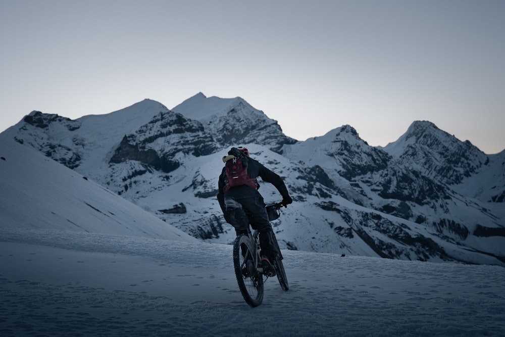 Un homme dévalant à vélo une pente enneigée