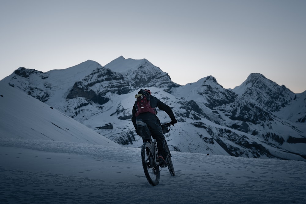 a man riding a bike down a snow covered slope