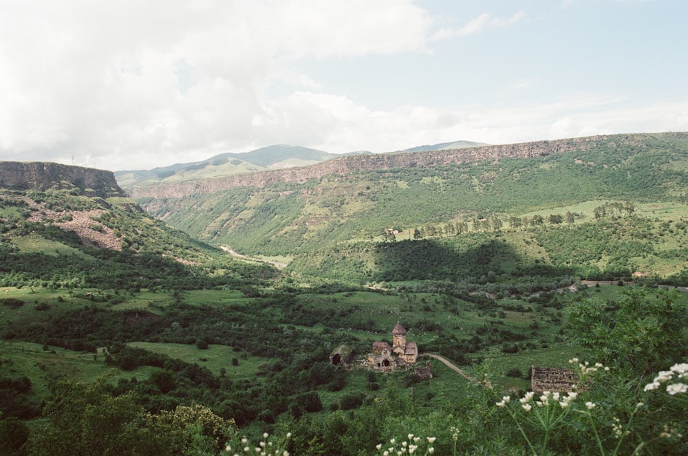 a scenic view of a valley with a church in the middle