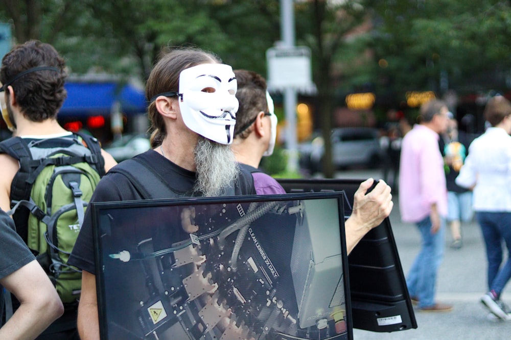 a man with a white mask is holding a sign
