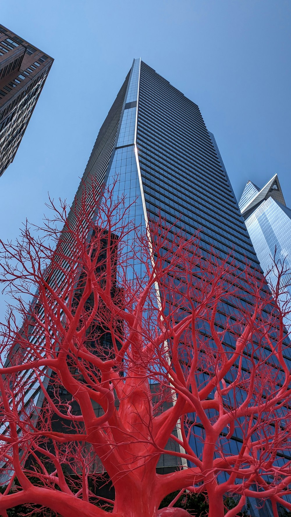 a red sculpture in front of a tall building