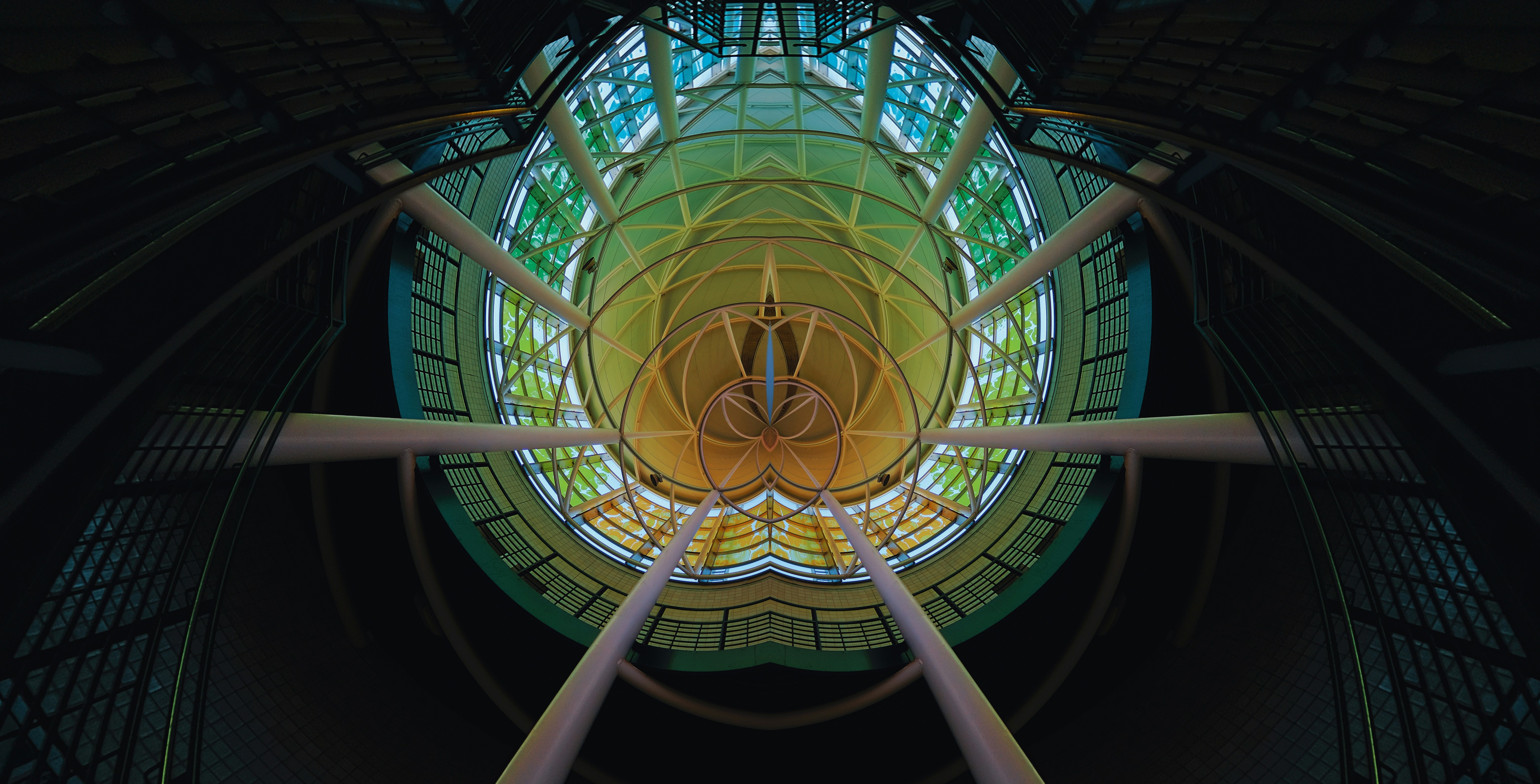 an abstract picture of a clock in the center of a building, An eerie contortion of a liminal space tunneling forward into dark oblivion with white pillars, window colors ranging from red to blue, and warm, cozy lighting with a nostalgic, homely feel.