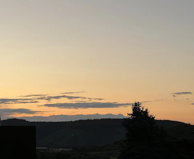 Sunset over a gently sloping lot with distant hills and open skies.