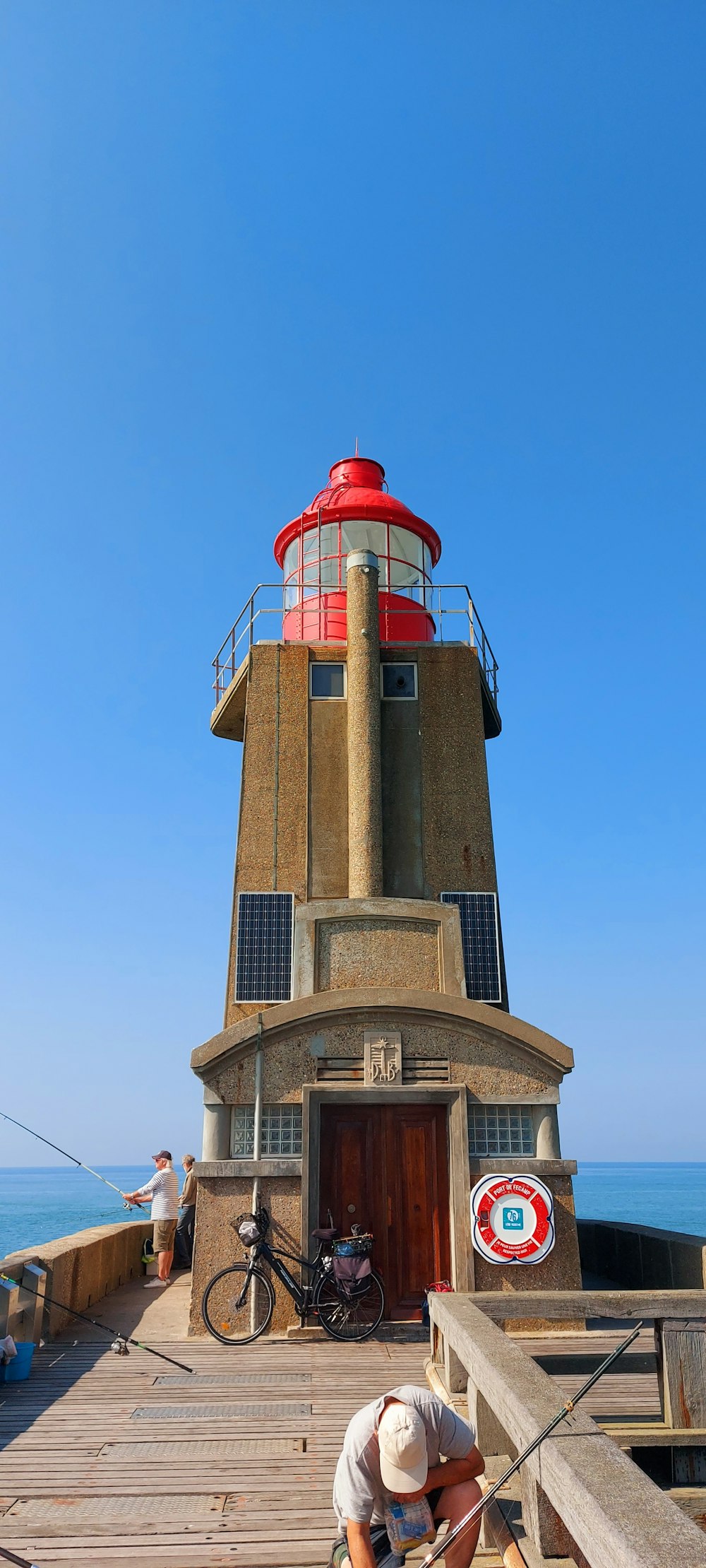 a man kneeling down next to a light house