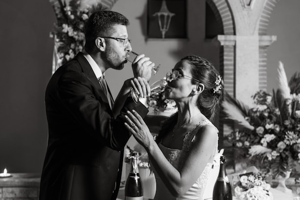A joyful couple sharing a toast at their beautifully decorated wedding reception.