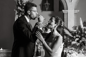 A happy couple sharing a toast surrounded by friends in a cozy, warmly lit reception.