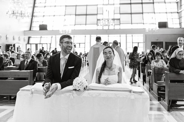 Guests seated inside the church, smiling and watching the ceremony with warm light streaming through the windows.
