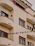 Close-up of a securely installed pigeon net on a sunny apartment balcony in Ernakulam.