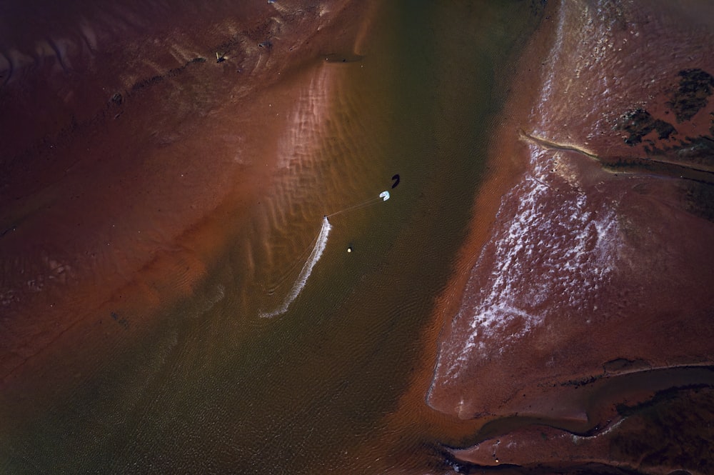 an aerial view of a person on a surfboard in a body of water