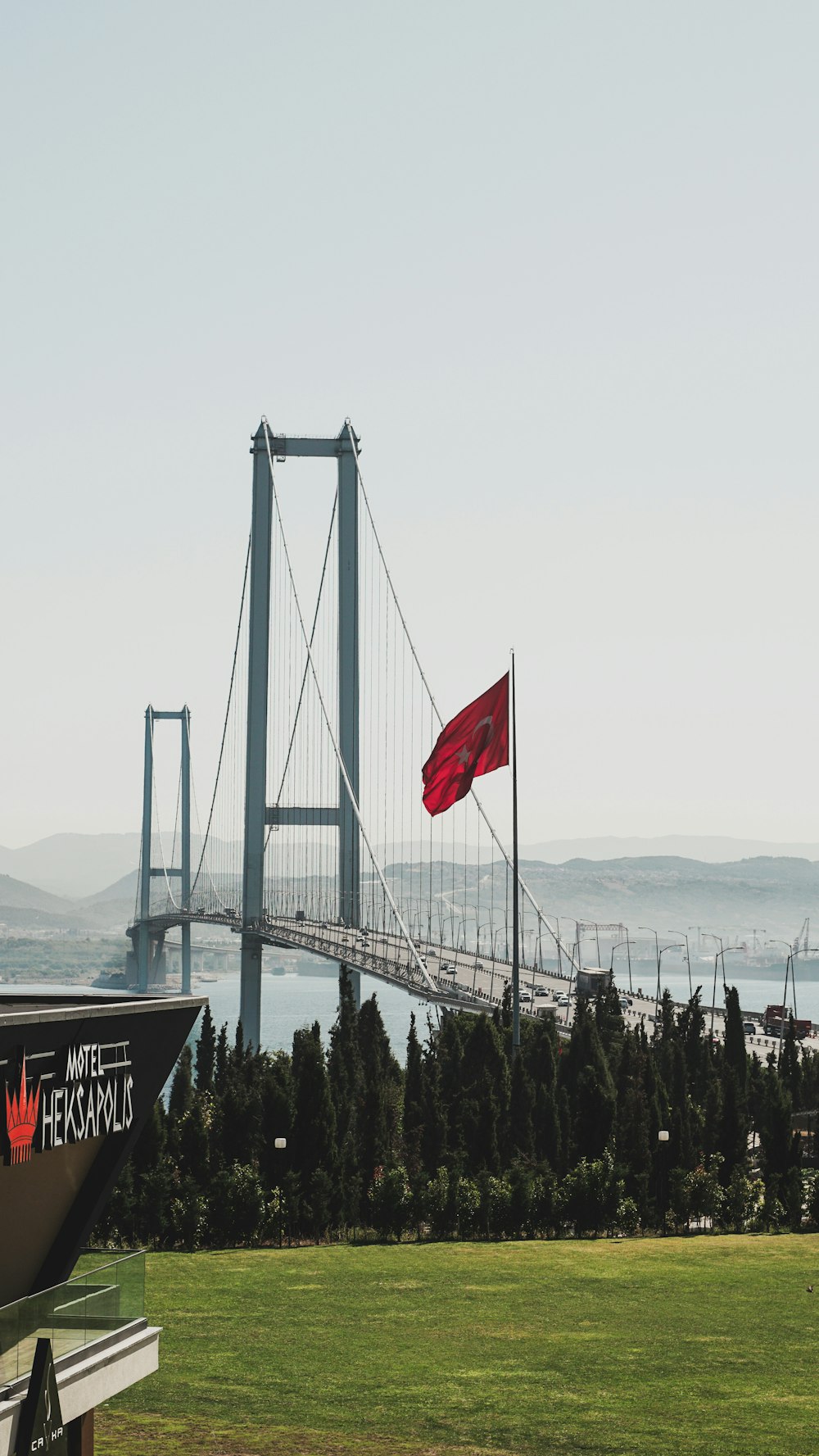 Una vista de un puente con una bandera roja en primer plano