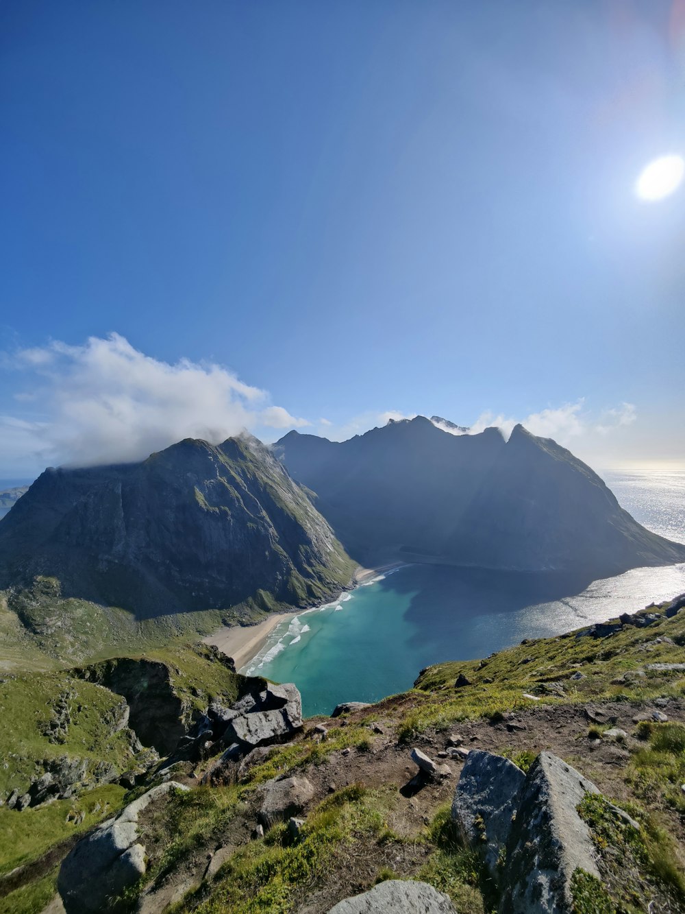 the sun is shining over a mountain lake