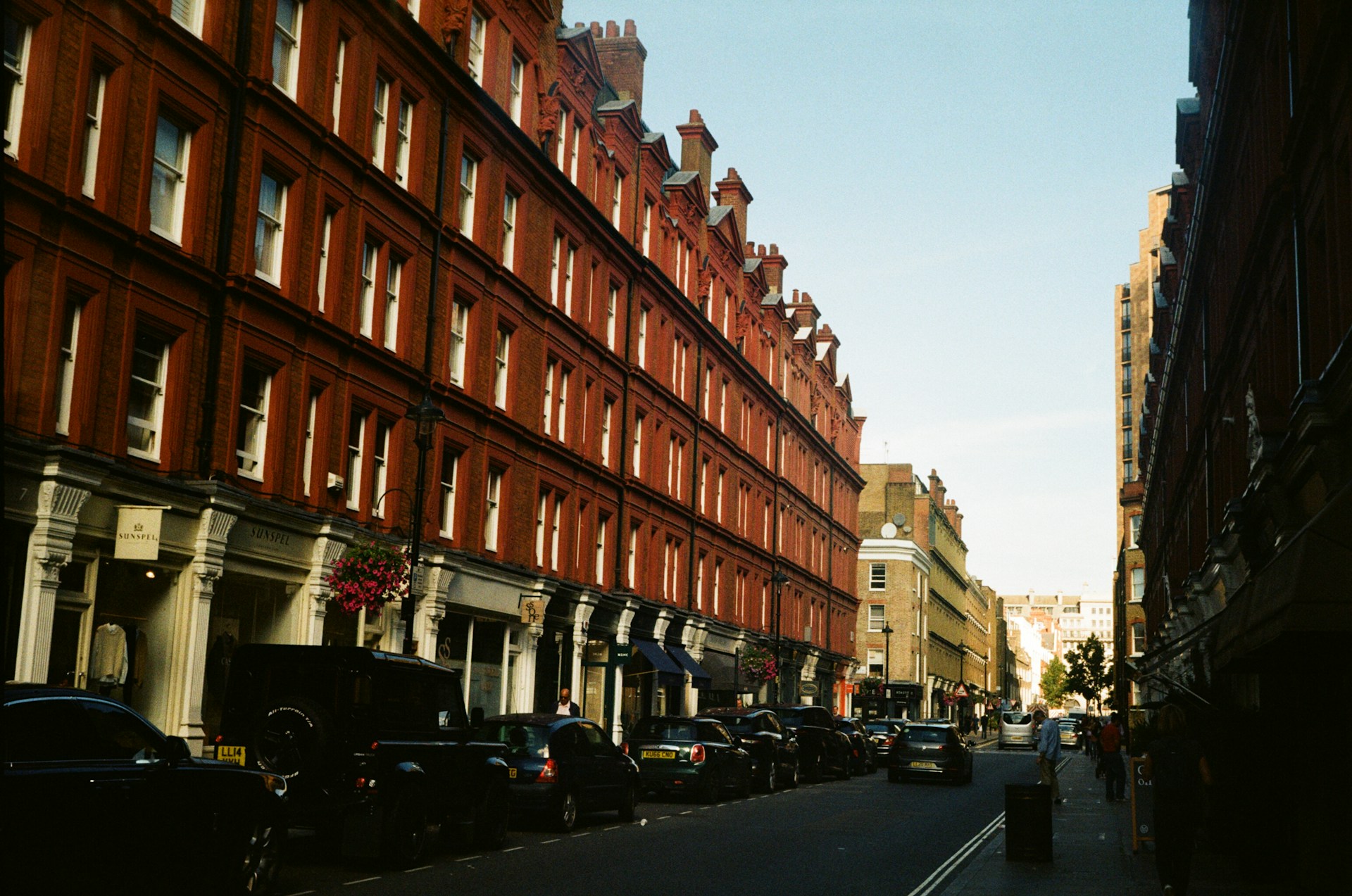 a city street lined with tall red brick buildings