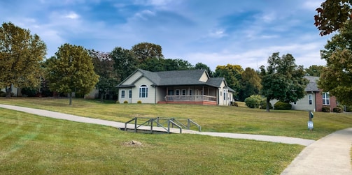 Before and after photo of a renovated suburban home with fresh paint and landscaping.