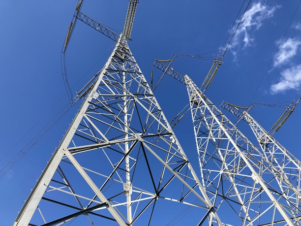High-voltage transmission towers standing tall against a clear blue sky.