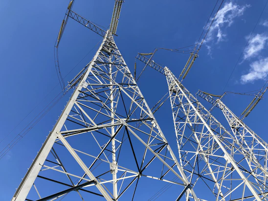 Modern electrical power station with high-voltage transmission towers under a clear sky.