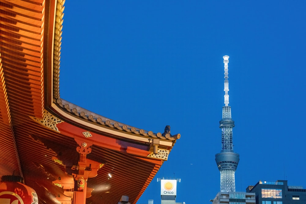 a tall tower towering over a city next to a tall building