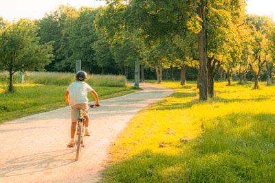 A happy female cyclist riding pain-free on a mountain trail, sunlit and focused.