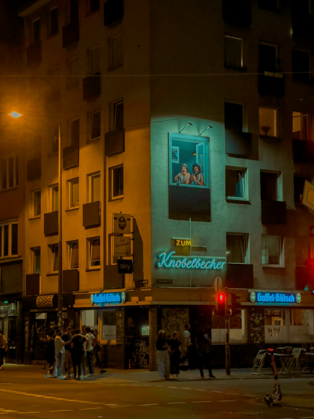 a group of people standing outside of a building at night