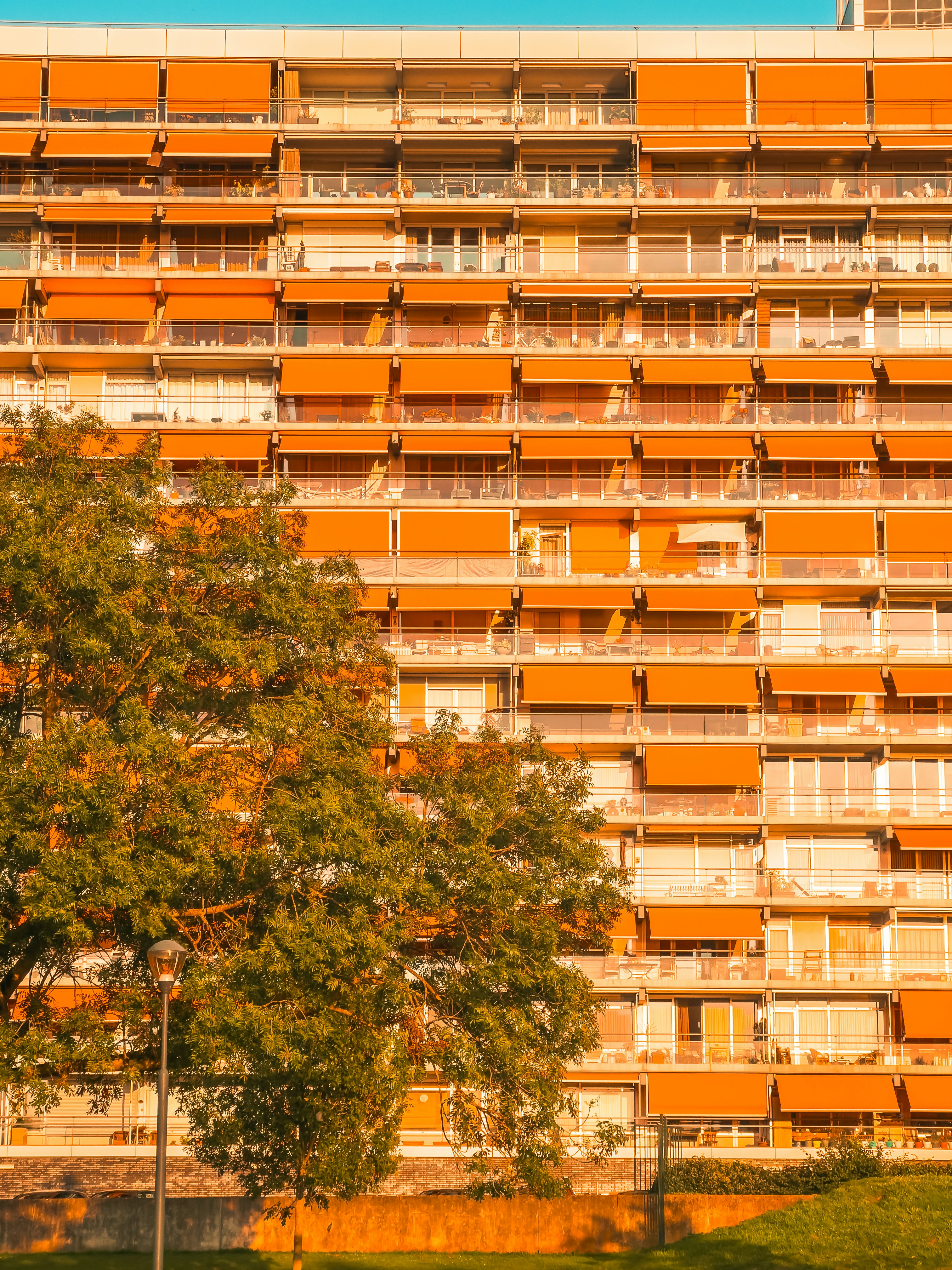 Un alto edificio naranja con balcones y balcones en él