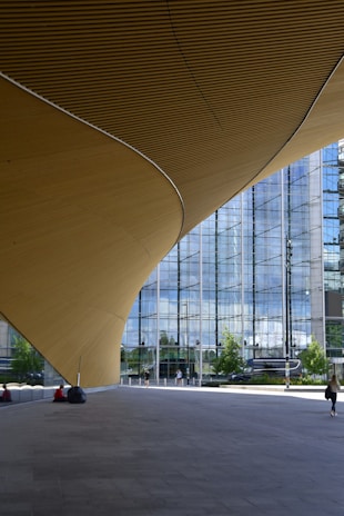 a person walking down a walkway in front of a building