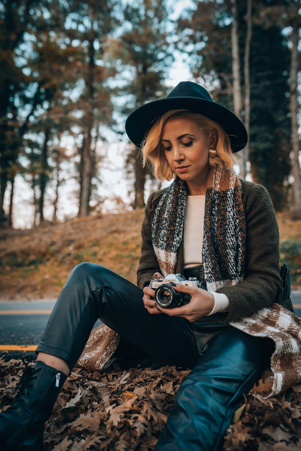 a woman sitting on the ground holding a camera