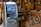 An ATM situated indoors among various wooden and metal antique machinery, creating a juxtaposition between modern technology and historical equipment.