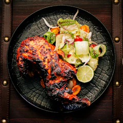 A beautifully plated continental dish featuring grilled chicken and vegetables.