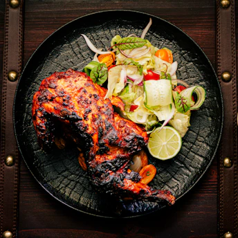 A beautifully plated continental dish featuring grilled chicken and vegetables.