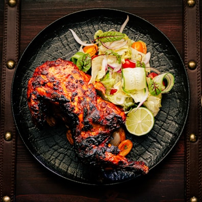 A vibrant plate of grilled chicken served with colorful sides.