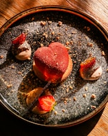 Close-up of a heart-shaped chocolate dessert with delicate rose petals.