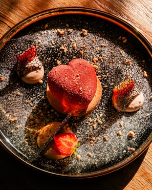 Close-up of a heart-shaped chocolate dessert with delicate rose petals.
