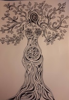 An intricate black and white drawing of a tree with human-like features. The trunk resembles a woman's body, transitioning into branches as arms and a leafy canopy forming the head and hair. Detailed patterns, including flowers and a peace sign, adorn the trunk.