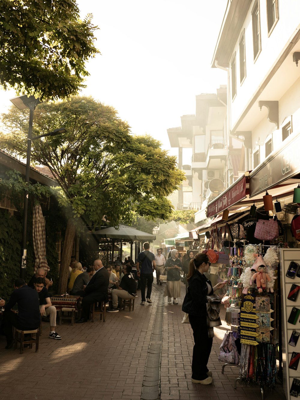 a group of people walking down a street next to shops