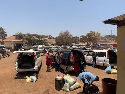 A fleet manager reviewing vehicle data on a tablet in a busy parking lot.