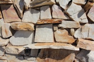Rustic sandstone cobbles arranged to show their warm hues and rough textures perfect for outdoor use.
