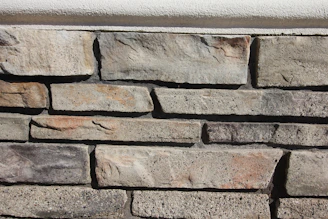 High-resolution shot of a modern stone wall featuring large rectangular tiles in varying shades of grey.