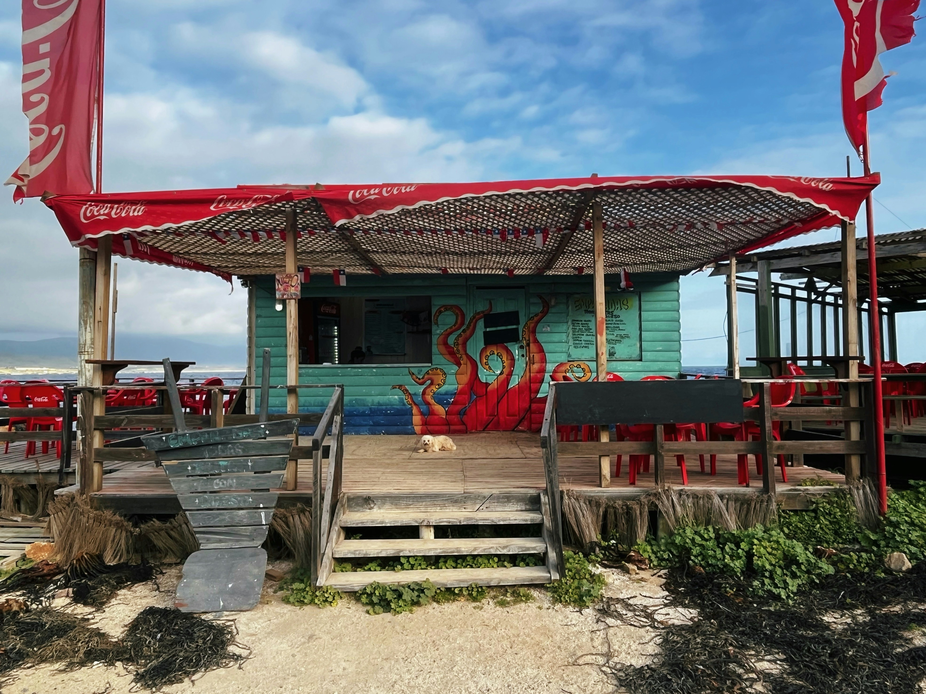 a building with a red roof and a dog on the porch