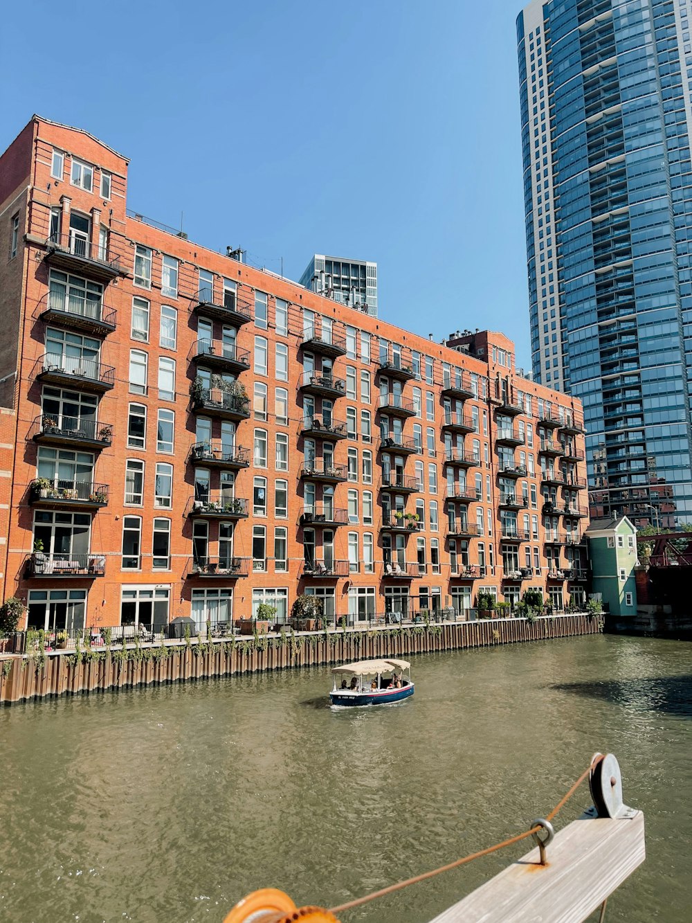 a boat traveling down a river next to tall buildings