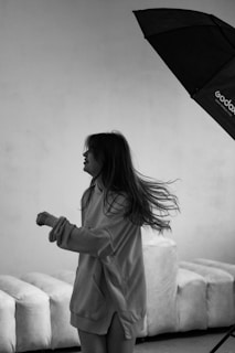 Artful shot of a Lumina Apparel hoodie draped over a modern chair in a sunlit studio corner.