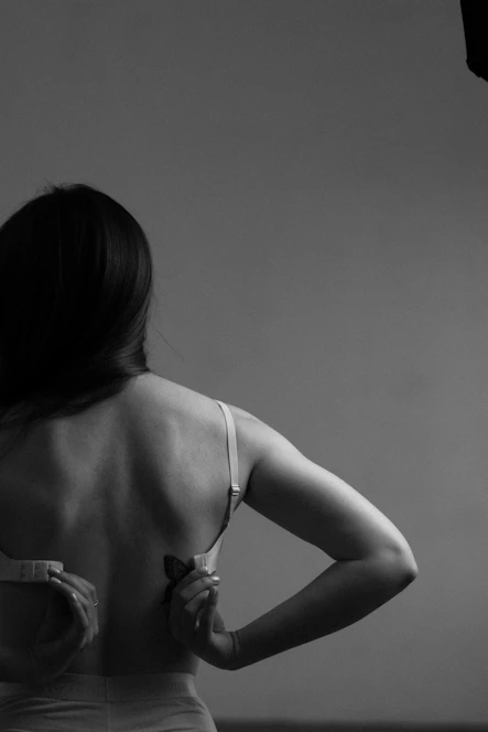 a woman in a bra looking at her reflection in a mirror
